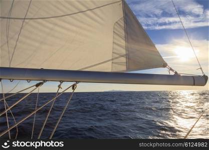 Rigging, ropes, shrouds and sail crop on the yacht at sunset