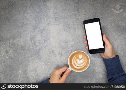 Right hand holding a telephone and left hand holding a cup of coffee with copy to write.
