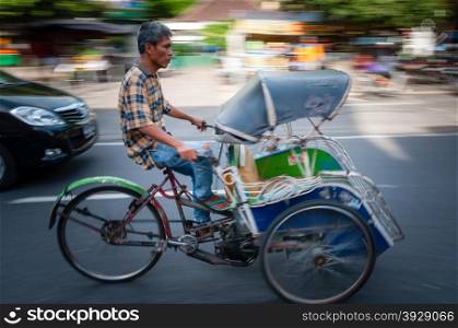 Rikshaw driver on a Main Street in Yogyakarta, Java, Indonesia