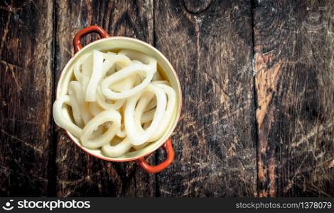 Rings of sea squid in a bowl. On a wooden background.. Rings of sea squid in a bowl.