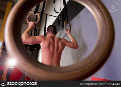 Rings workout man at gym hanging rear back view