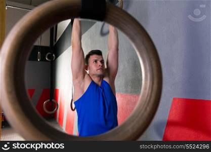 Rings workout man at gym muscle ups hanging