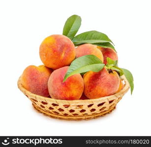 Ripe and beautiful peaches in a basket close-up on a white background.