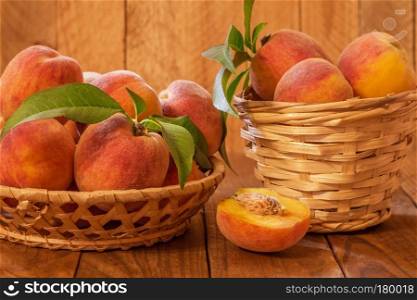 Ripe and beautiful peaches in a basket on a wooden background.