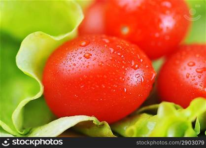 ripe and juicy cherry tomatoes and lettuce on bamboo napkin