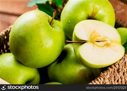Ripe apples in a basket on the table. On a wooden background. High quality photo. Ripe apples in a basket on the table.