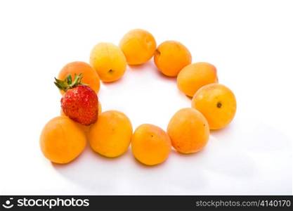 Ripe apricots and berry of strawberry on white background