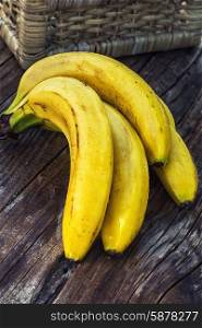 Ripe bananas. Ligament large ripe and fragrant bananas on wooden background.