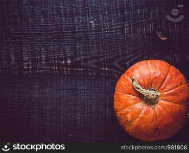 Ripe, bright pumpkin lying on a wooden surface. Place for your inscription. Top view, close-up. Congratulations to loved ones, family, relatives, friends and colleagues. Ripe pumpkin lying on a wooden surface