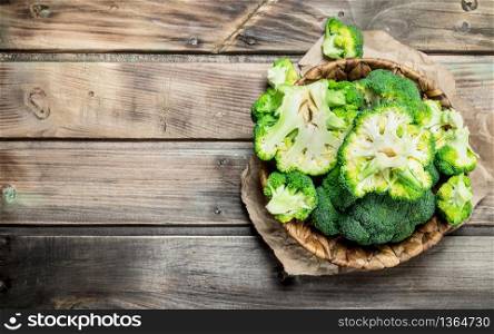 Ripe broccoli in the basket. On a wooden background.. Ripe broccoli in the basket.