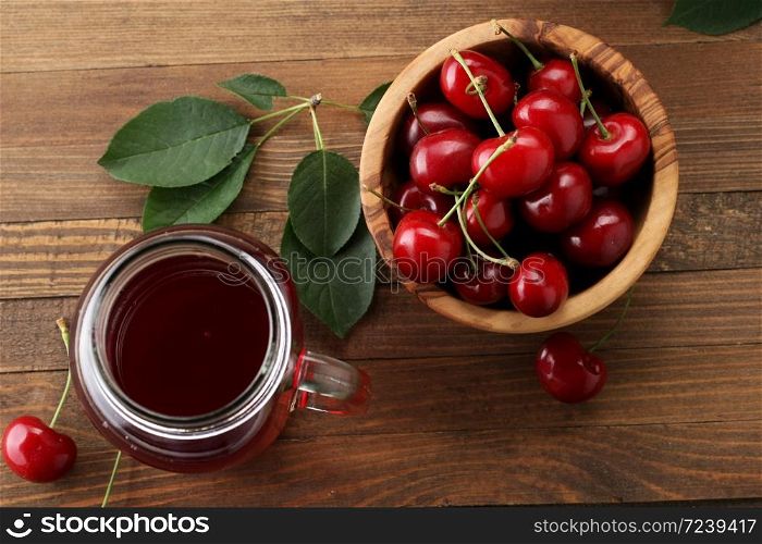 ripe cherries in a wooden bowl on the background of wooden boards