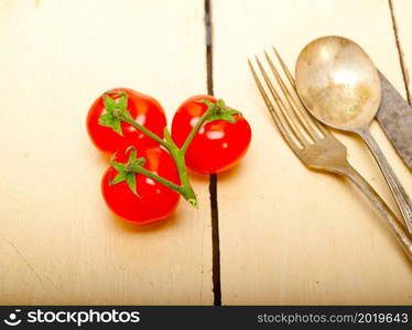 ripe cherry tomatoes cluster over white rustic wood table