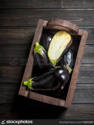 Ripe eggplant in the box. On black wooden background. Ripe eggplant in the box.