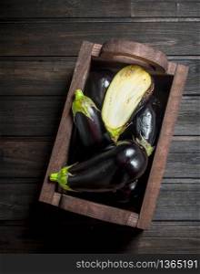 Ripe eggplant in the box. On black wooden background. Ripe eggplant in the box.
