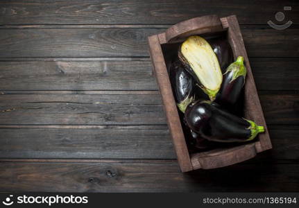 Ripe eggplant in the box. On black wooden background. Ripe eggplant in the box.