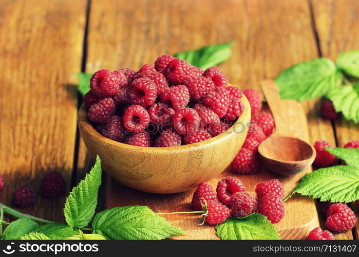 Ripe fresh raspberry in wooden bowl on table. Ripe fresh raspberry in wooden bowl