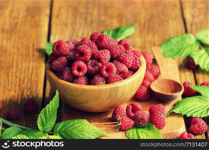 Ripe fresh raspberry in wooden bowl on table. Ripe fresh raspberry in wooden bowl