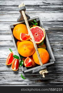 Ripe grapefruit in a wooden box. On wooden background. Ripe grapefruit in a wooden box.