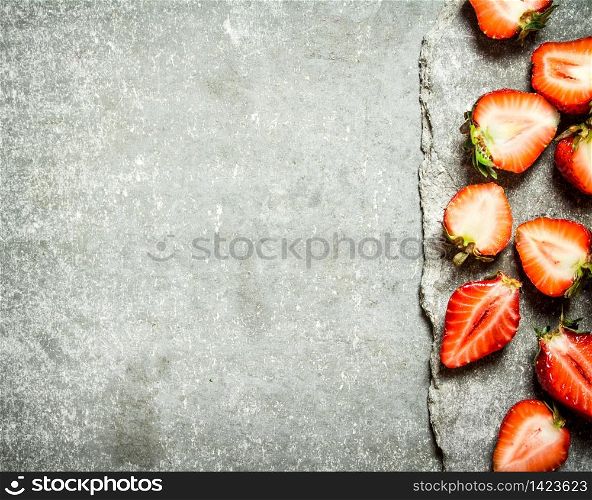 Ripe halved strawberries. On the stone table.. Ripe halved strawberries.