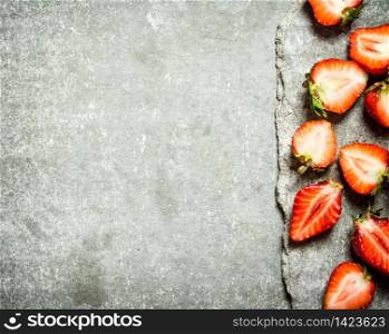 Ripe halved strawberries. On the stone table.. Ripe halved strawberries.
