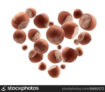 Ripe hazelnuts in the shape of a heart on a white background.. Ripe hazelnuts in the shape of a heart on a white background