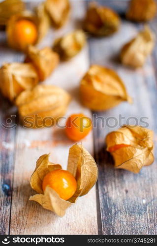 ripe healthy orange physalis over wooden board