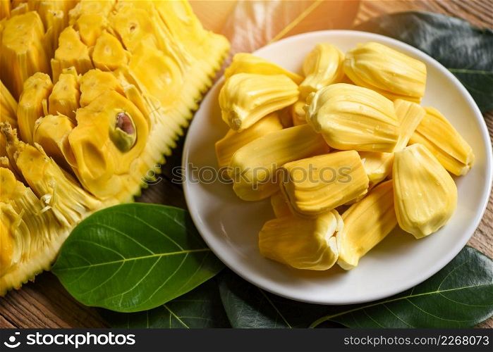 Ripe jackfruit peeled tropical fruit fresh from jackfruit tree, jackfruit on white plate with leaf on wooden background