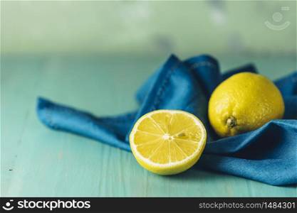 Ripe juicy lemon on wooden turquoise table surface. Close up, copy space for you text, shallow depth of the field.