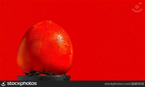 Ripe, juicy orange persimmon fruit isolated on bright red background. Wallpaper idea or space decoration. Drops of water on the sale of persimmons