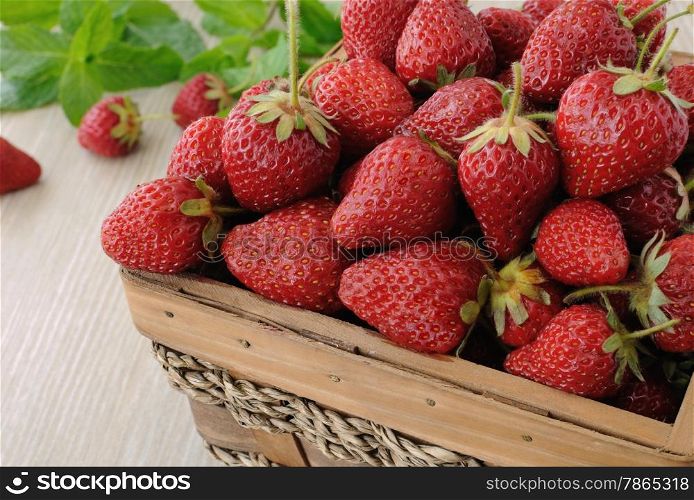 Ripe, juicy strawberries in a basket on the table close-up