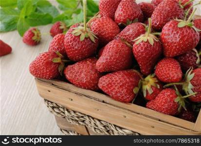 Ripe, juicy strawberries in a basket on the table close-up