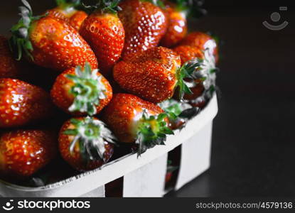 ripe juicy strawberries on a wooden table in a basket