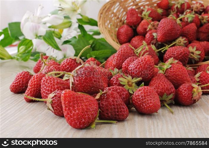 Ripe, juicy strawberries sprinkled on the table close-up