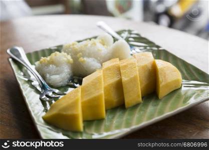 ripe mango with sticky rice topping with coconut milk and nut