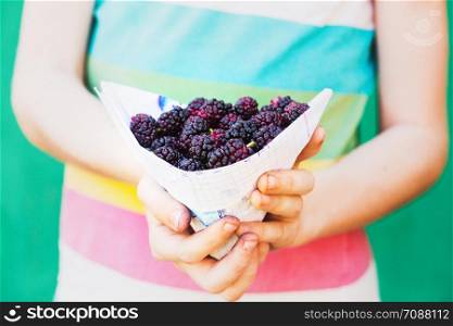 ripe mulberry in the hands of a girl. bright tasty summer