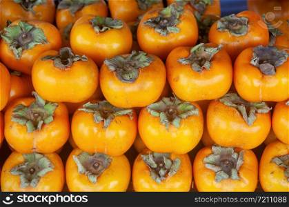 Ripe orange persimmon fruit on market stall
