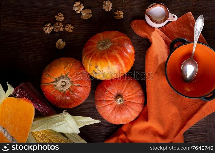 ripe orange pumkins served at wooden brown table with orange bowl and coconut milk. flat lay. healthy life concept