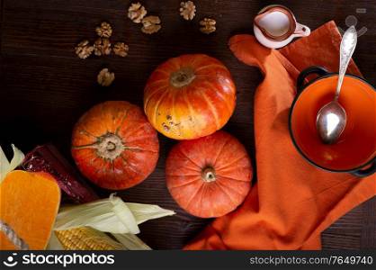ripe orange pumkins served at wooden brown table with orange bowl and coconut milk. flat lay. healthy life concept