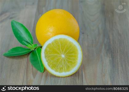 ripe orange with leaves on wooden background