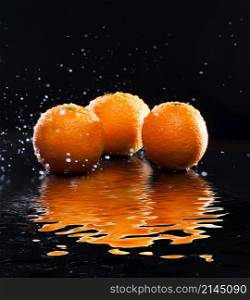 ripe oranges lying on the mirror in a spray of water. ripe oranges