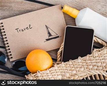 Ripe oranges, wicker basket, sunblock and sunglasses. Top view, close-up. Concept of leisure and travel. Ripe oranges, wicker basket and sunglasses. Top view