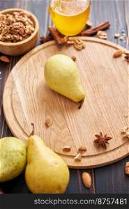 Ripe organic pear on the wooden cutting board Board at domestic kitchen.. Ripe organic pear on the wooden cutting board Board at domestic kitchen