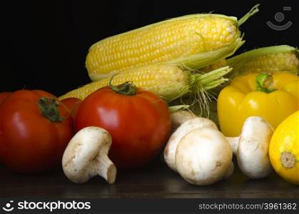 Ripe organic vegetables on wooden table at dark background. Ripe organic vegetables on wooden table at dark background still life