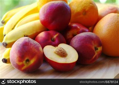 ripe peaches. bananas and citrus fruits in table