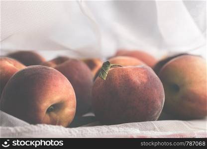 Ripe peaches in a reusable mesh shopping bag. Reduce the plastic wrapping concept. Plastic packaging management concept. Groceries in an eco bag.