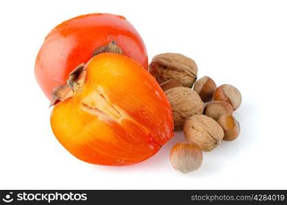 Ripe persimmons and nuts on white background.