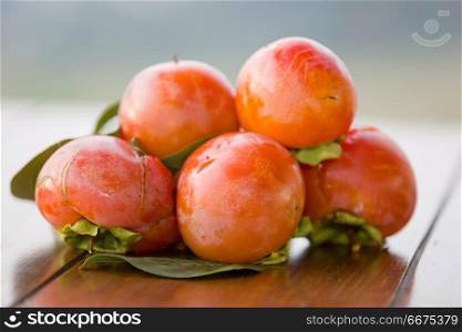 ripe persimmons on a table, outdoor. persimmons