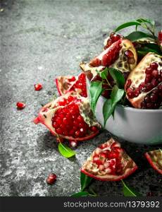 Ripe pieces of pomegranate in a bowl. On a rustic background.. Ripe pieces of pomegranate in a bowl.