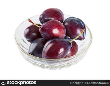 Ripe plums in a crystal dish isolated on white background