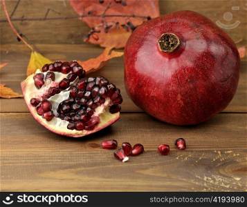 Ripe Pomegranate With Red Seeds On Wooden Background ,Close Up